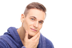 Young man checking the skin on his face