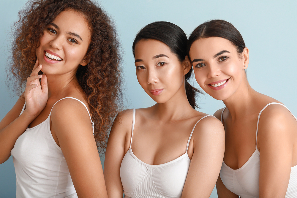 Three women with glowing skin smiling confidently post Skinpen Micro-Needling treatment.